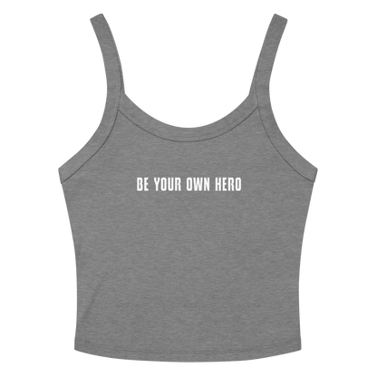"Be your own here" printed on a athletic heather women's micro-rib tanktop laying on a flat surface amongst sunglasses and shorts