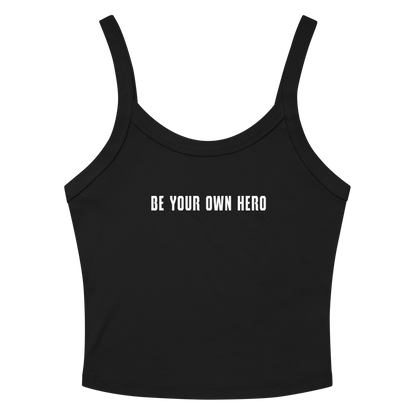 "Be your own here" printed on a solid black blend women's micro-rib tanktop laying on a flat surface amongst sunglasses and shorts