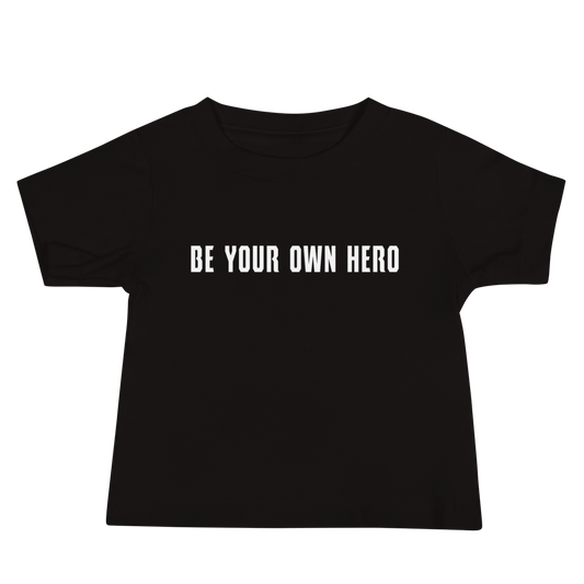 "Be your own here" printed on a black baby jersey short sleeve tee laying on a flat surface