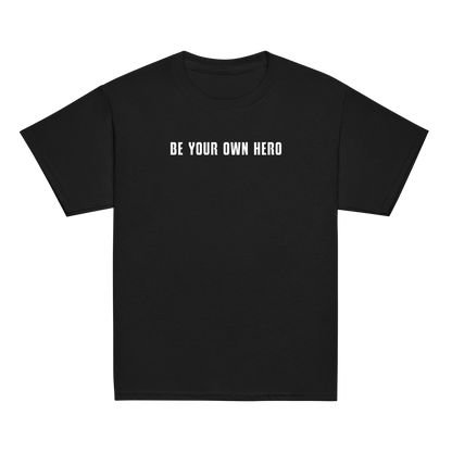 "Be your own here" printed on a black youth classic tee laying on a flat surface