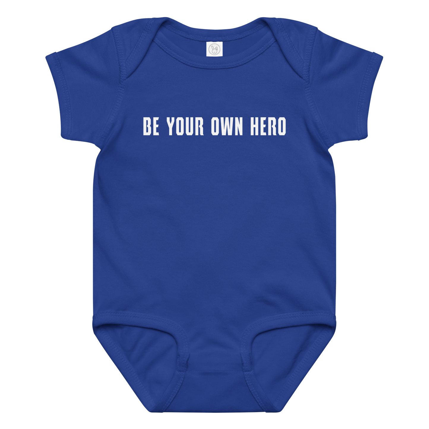 "Be your own here" printed on a royal baby jersey bodysuit laying on a flat surface amongst other clothes