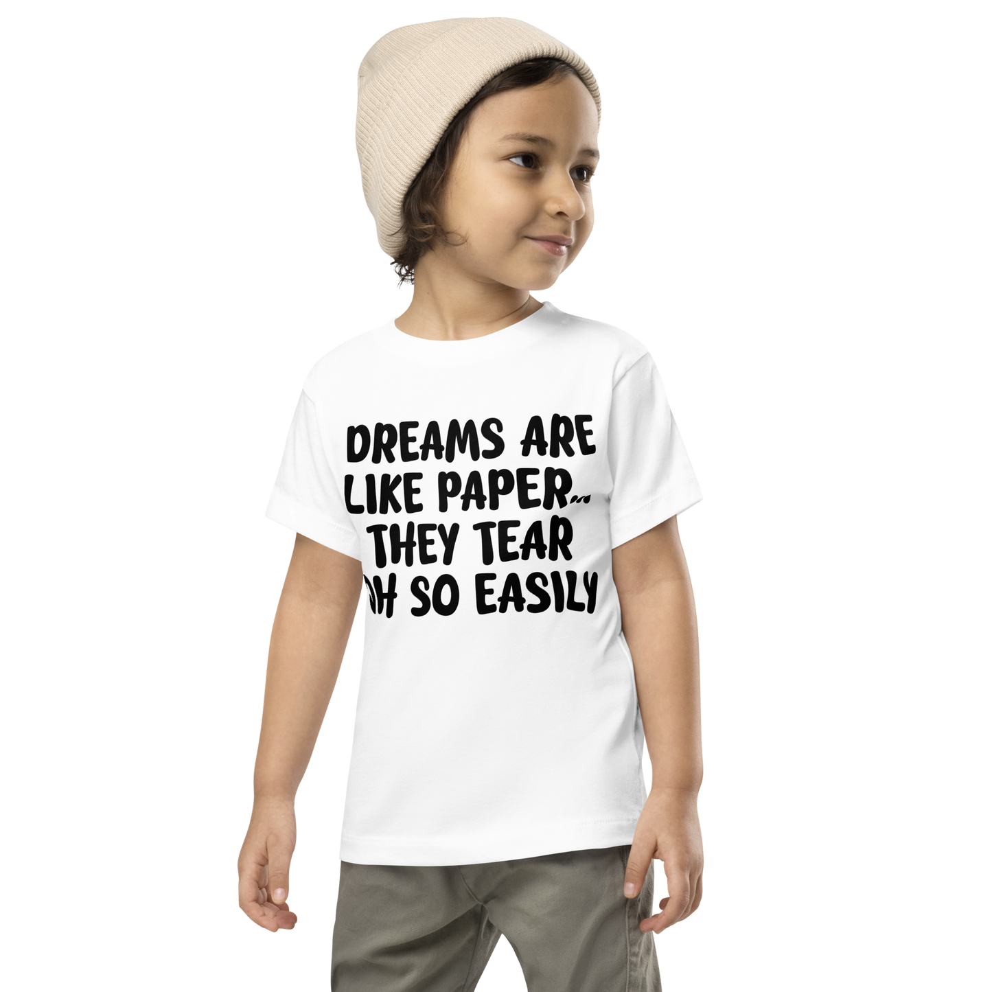 "Dreams are like paper, they tear oh so easily" printed on a white toddler short sleeve tee worn by a male wearing a cap