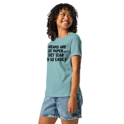 "Dreams are like paper, they tear oh so easily" printed on a heather blue lagoon women's relaxed t-shirt worn by a female