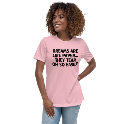 "Dreams are like paper, they tear oh so easily" printed on a pink women's relaxed t-shirt worn by a female