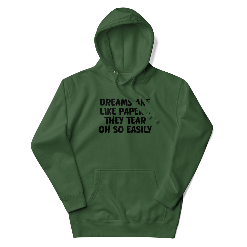 "Dreams are like paper, they tear oh so easily" printed on a forest green unisex hoodie laying on a flat surface with the hood up