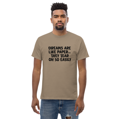 "Dreams are like paper, they tear oh so easily" printed on a brown savana unisex classic tee worn by a male