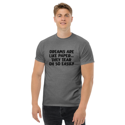 "Dreams are like paper, they tear oh so easily" printed on a graphite heather unisex classic tee worn by a male