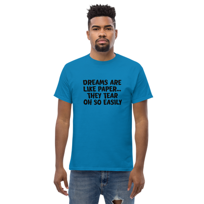 "Dreams are like paper, they tear oh so easily" printed on a sapphire unisex classic tee worn by a male