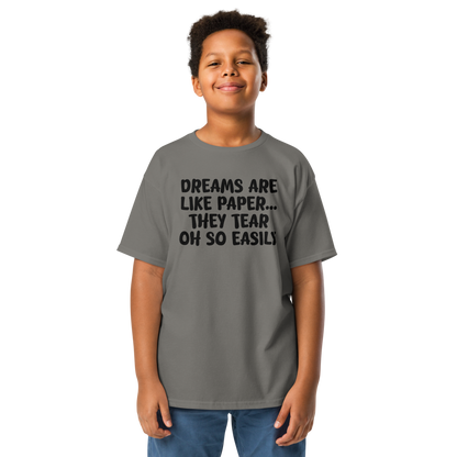"Dreams are like paper, they tear oh so easily" printed on a charcoal youth classic tee worn by a male