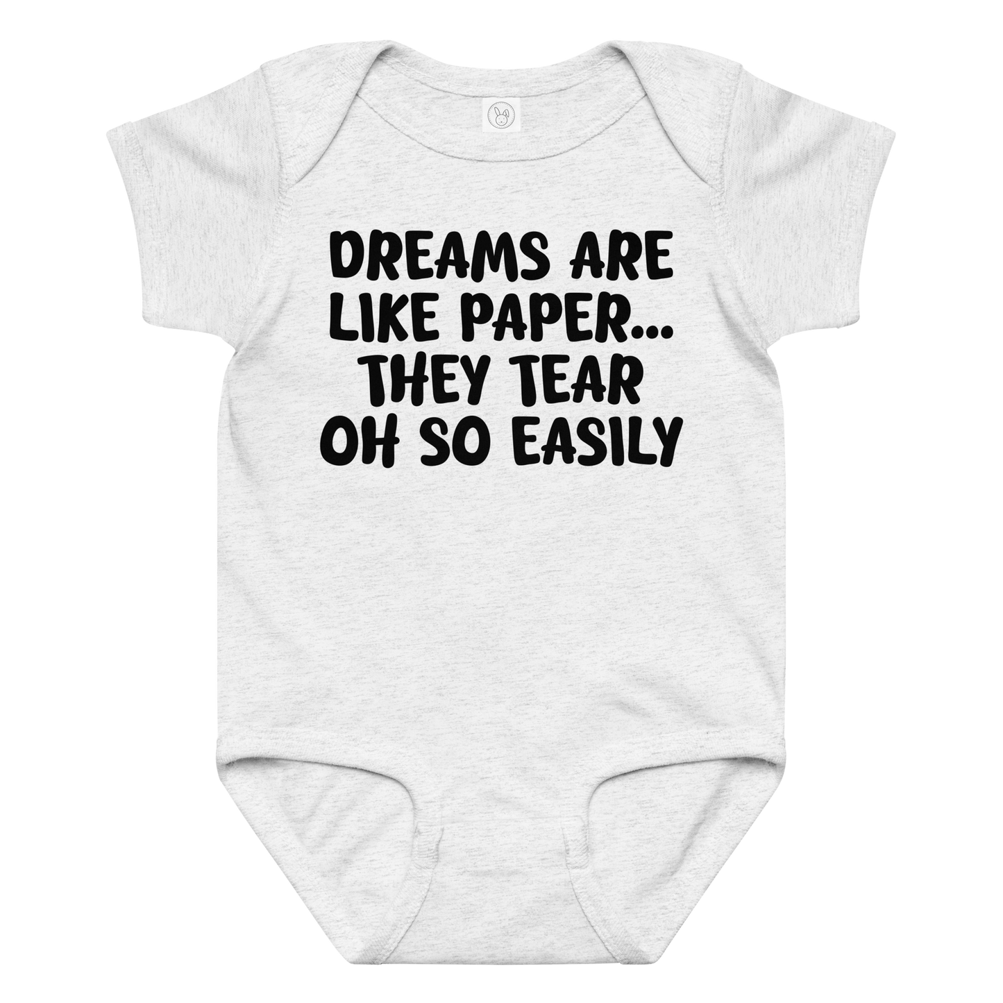 "Dreams are like paper, they tear oh so easily" printed on a ash baby jersey bodysuit laying on a flat surface amongst other clothes