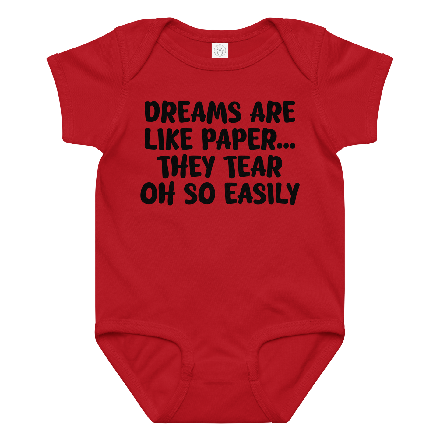 "Dreams are like paper, they tear oh so easily" printed on a red baby jersey bodysuit laying on a flat surface amongst other clothes