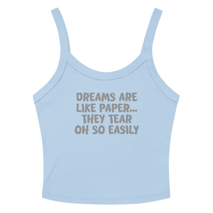 "Dreams are like paper, they tear oh so easily" printed on a solid baby blue blend women's micro-rib tanktop laying on a flat surface amongst sunglasses and shorts