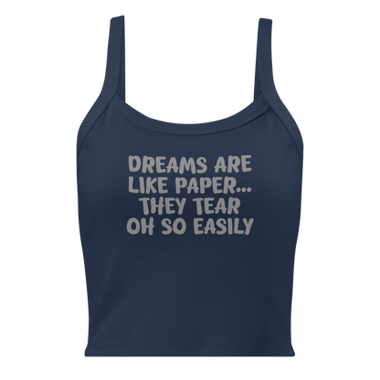 "Dreams are like paper, they tear oh so easily" printed on a solid navy blend women's micro-rib tanktop laying on a flat surface