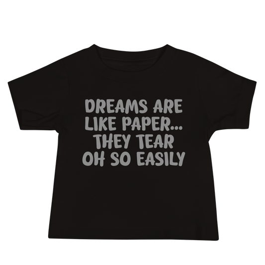 "Dreams are like paper, they tear oh so easily" printed on a black baby jersey short sleeve tee laying on a flat surface