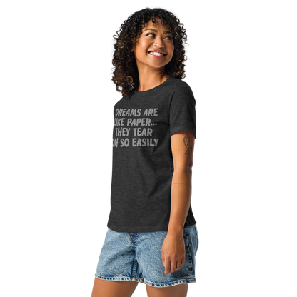 "Dreams are like paper, they tear oh so easily" printed on a dark grey heather women's relaxed t-shirt worn by a female