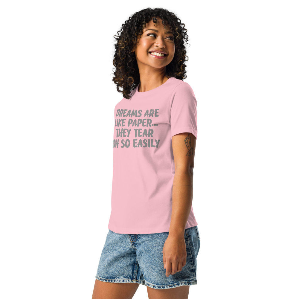 "Dreams are like paper, they tear oh so easily" printed on a pink women's relaxed t-shirt worn by a female