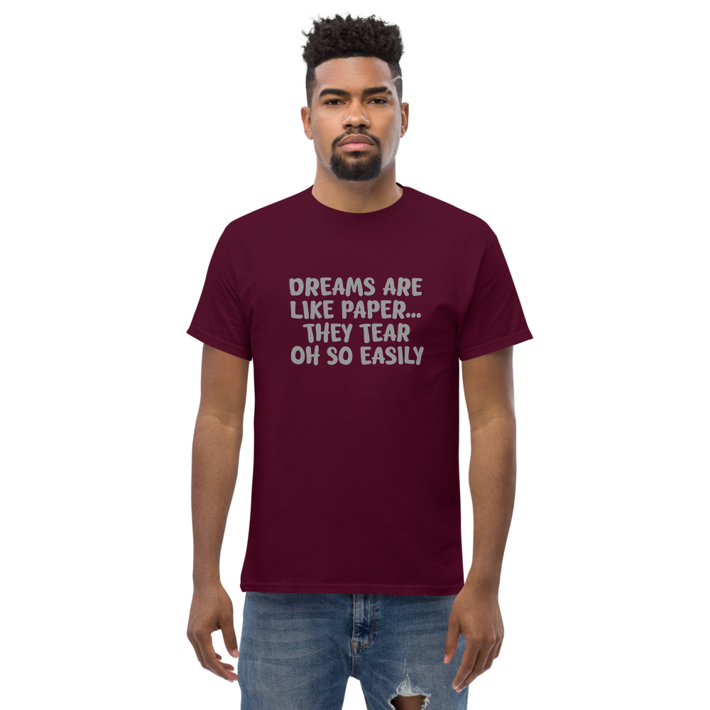 "Dreams are like paper, they tear oh so easily" printed on a maroon unisex classic tee worn by a male