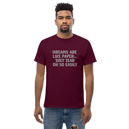 "Dreams are like paper, they tear oh so easily" printed on a maroon unisex classic tee worn by a male