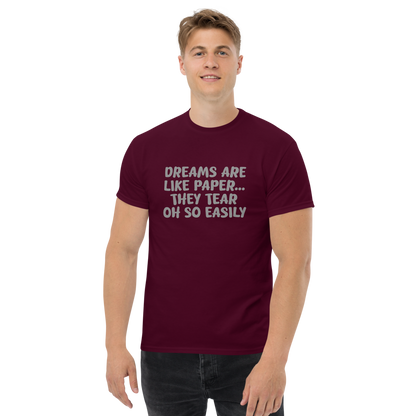 "Dreams are like paper, they tear oh so easily" printed on a maroon unisex classic tee worn by a male