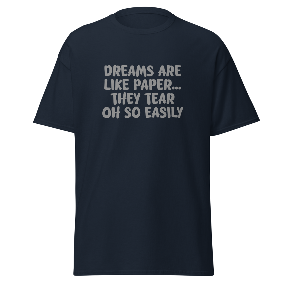 "Dreams are like paper, they tear oh so easily" printed on a navy unisex classic tee laying on a flat surface