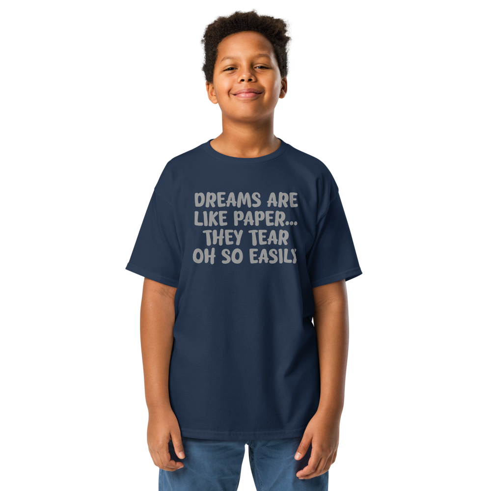 "Dreams are like paper, they tear oh so easily" printed on a navy youth classic tee worn by a male