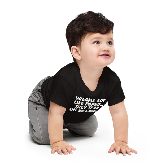 "Dreams are like paper, they tear oh so easily" printed on a black baby jersey short sleeve tee worn by a male who is crawling