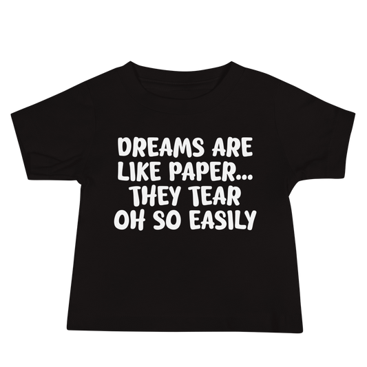 "Dreams are like paper, they tear oh so easily" printed on a black baby jersey short sleeve tee laying on a flat surface