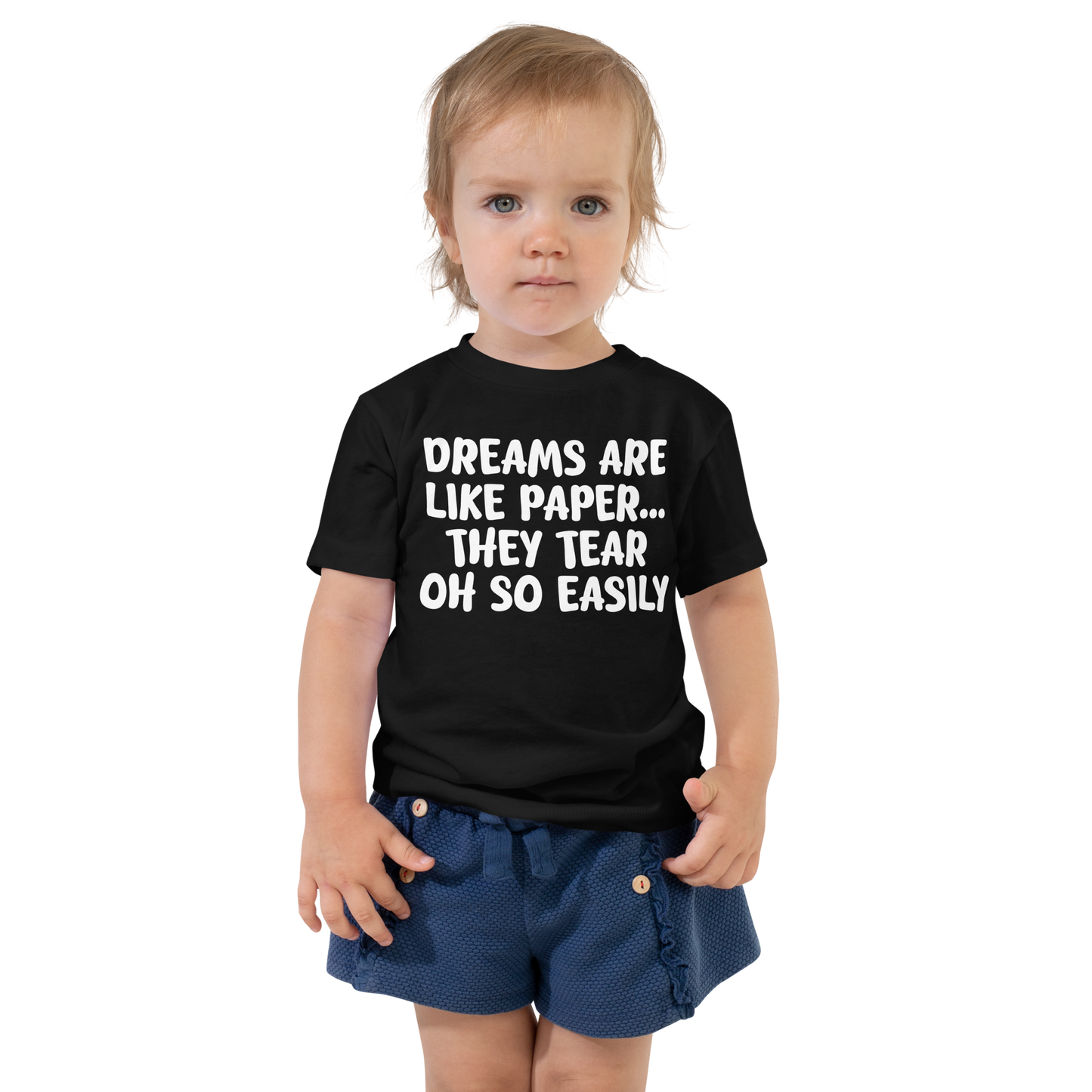 "Dreams are like paper, they tear oh so easily" printed on a black toddler short sleeve tee worn by a female