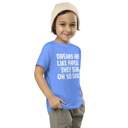 "Dreams are like paper, they tear oh so easily" printed on a heather columbia blue toddler short sleeve tee worn by a male who is also wearing a knit cap