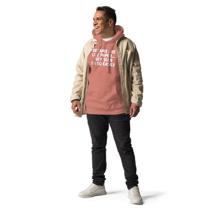 "Dreams are like paper, they tear oh so easily" printed on a dusty rose unisex hoodie worn by a male with a jacket on top