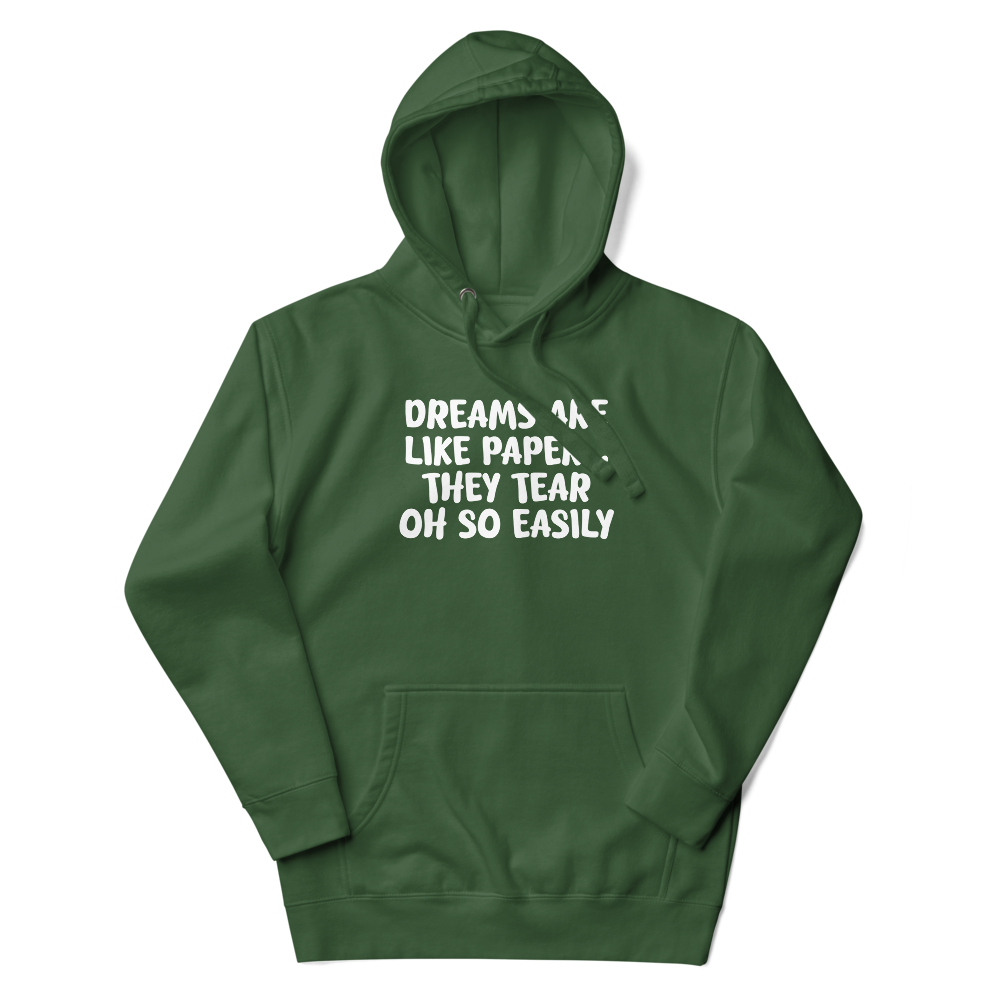 "Dreams are like paper, they tear oh so easily" printed on a forest green unisex hoodie laying on a flat surface with the hood up