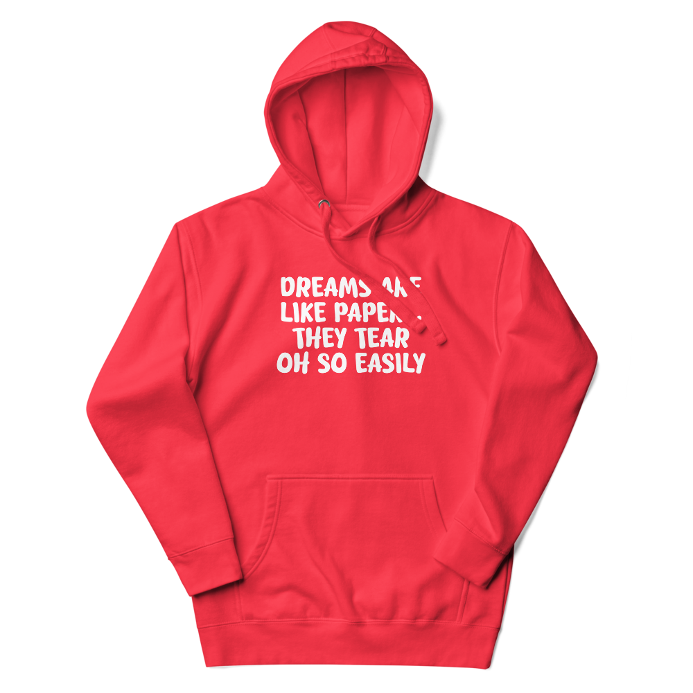"Dreams are like paper, they tear oh so easily" printed on a team red unisex hoodie laying on a flat surface with the hood up