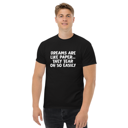 "Dreams are like paper, they tear oh so easily" printed on a black unisex classic tee worn by a male