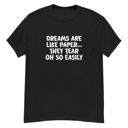 "Dreams are like paper, they tear oh so easily" printed on a black unisex classic tee laying on a flat surface