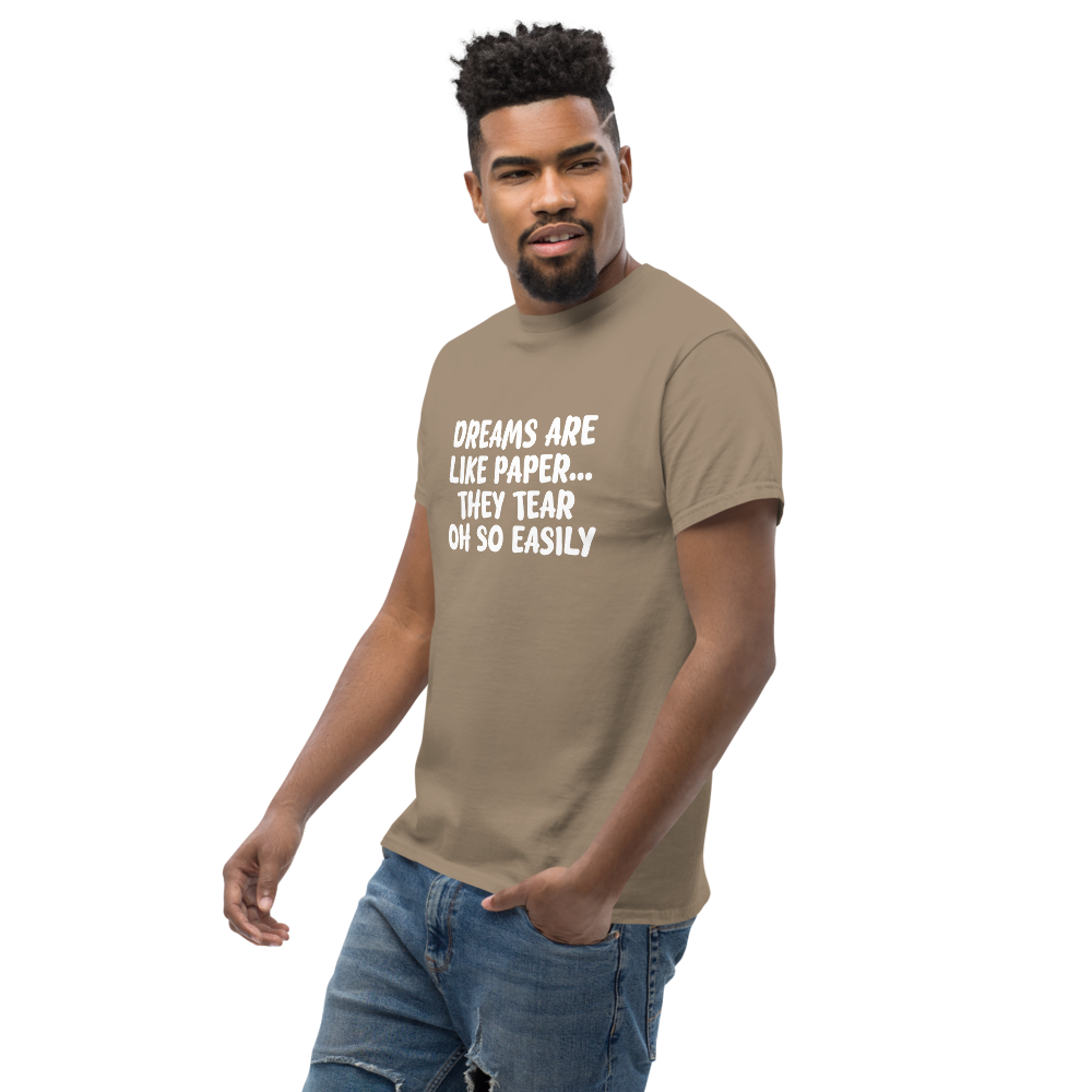 "Dreams are like paper, they tear oh so easily" printed on a brown savana unisex classic tee worn by a male