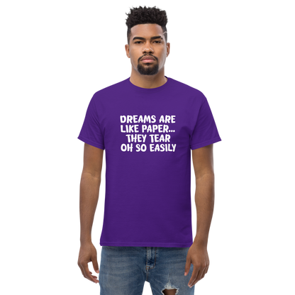 "Dreams are like paper, they tear oh so easily" printed on a purple unisex classic tee worn by a male