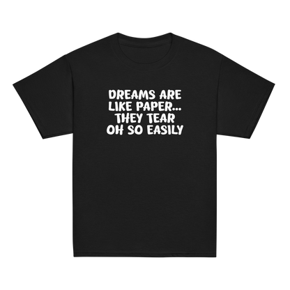 "Dreams are like paper, they tear oh so easily" printed on a black youth classic tee laying on a flat surface