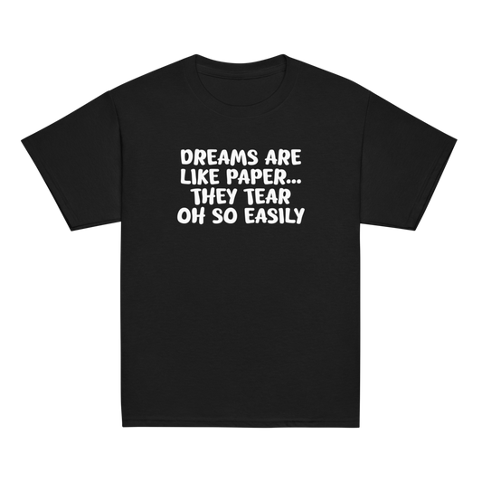 "Dreams are like paper, they tear oh so easily" printed on a black youth classic tee laying on a flat surface