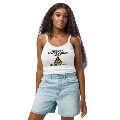 "There is a peacefulness and a rage inside us all" printed on a solid white blend women's micro-rib tanktop worn by a female