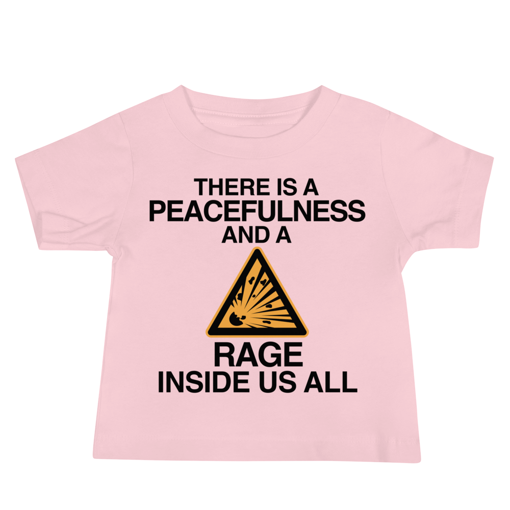 "There is a peacefulness and a rage inside us all" printed on a pink baby jersey short sleeve tee laying on a flat surface