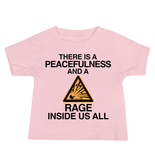 "There is a peacefulness and a rage inside us all" printed on a pink baby jersey short sleeve tee laying on a flat surface