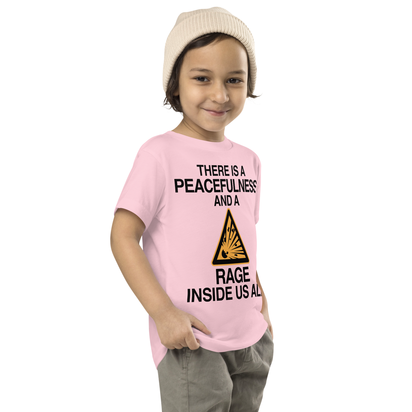 "There is a peacefulness and a rage inside us all" printed on a pink toddler short sleeve tee worn by a male who is also wearing a knit cap