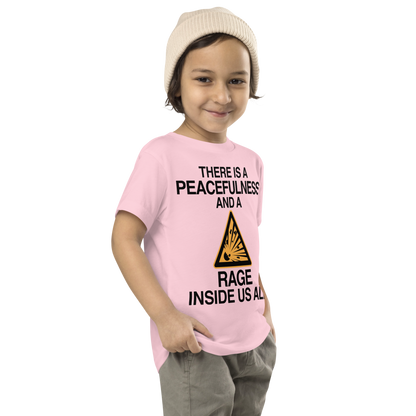 "There is a peacefulness and a rage inside us all" printed on a pink toddler short sleeve tee worn by a male who is also wearing a knit cap