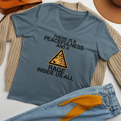 "There is a peacefulness and a rage inside us all" printed on a heather slate women's relaxed v-neck t-shirt laying on a flat surface amongst other clothes