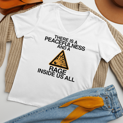 "There is a peacefulness and a rage inside us all" printed on a solid white blend women's relaxed v-neck t-shirt laying on a flat surface amongst other clothes