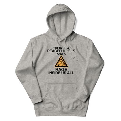 "There is a peacefulness and a rage inside us all" printed on a carbon grey unisex hoodie laying on a flat surface with the hood up