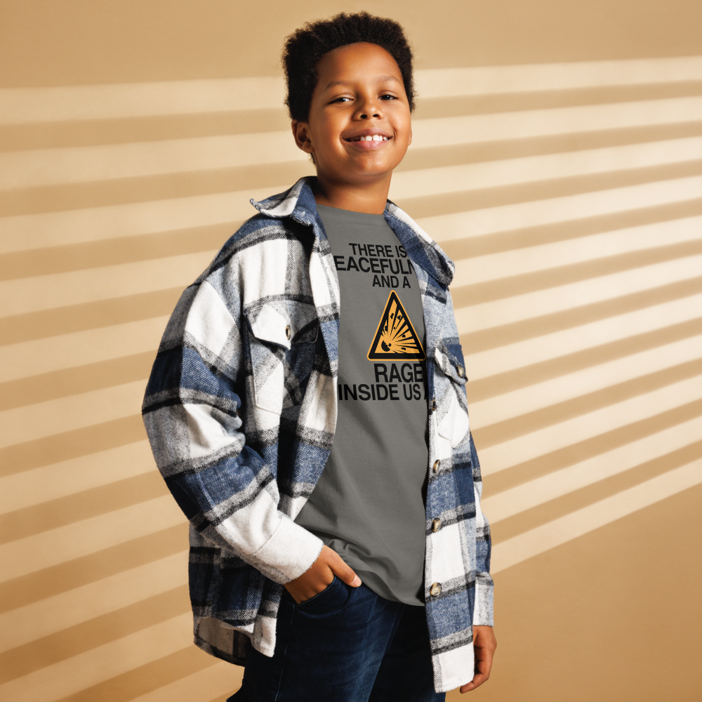 "There is a peacefulness and a rage inside us all" printed on a charcoal youth classic tee worn by a male also wearing a jacket