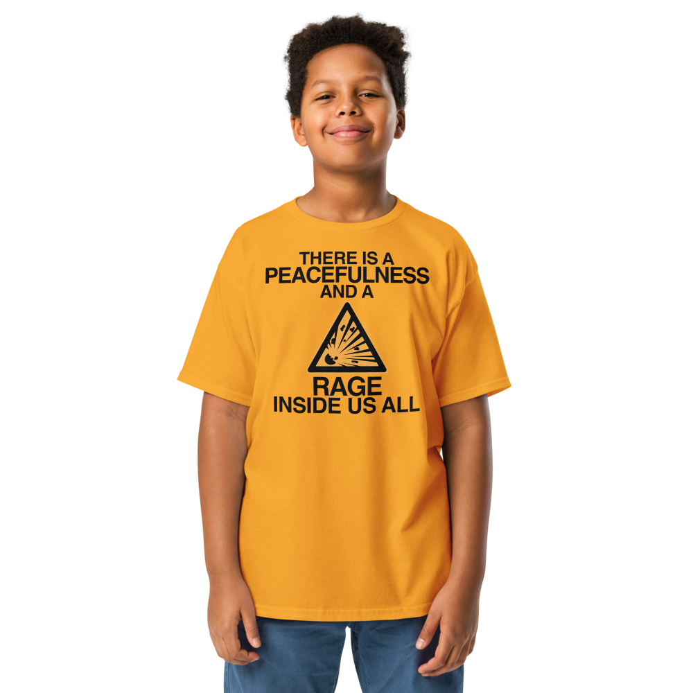 "There is a peacefulness and a rage inside us all" printed on a gold youth classic tee worn by a male