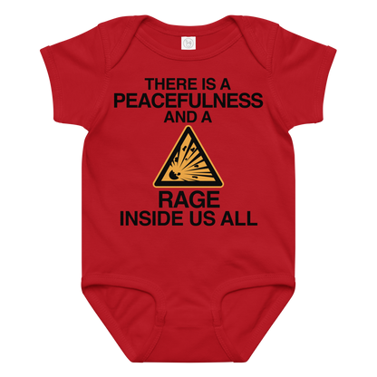 "There is a peacefulness and a rage inside us all" printed on a red baby jersey bodysuit laying on a flat surface amongst other clothes