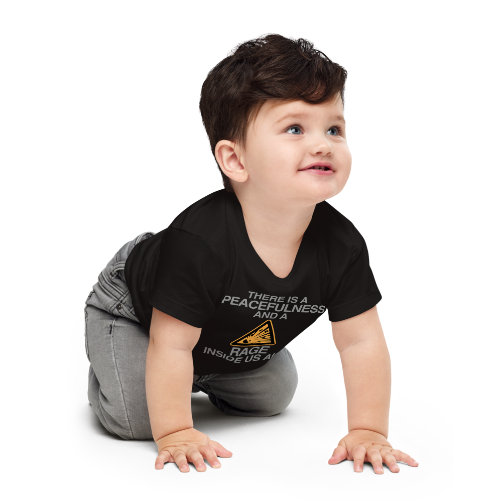 "There is a peacefulness and a rage inside us all" printed on a black baby jersey short sleeve tee worn by a male who is crawling